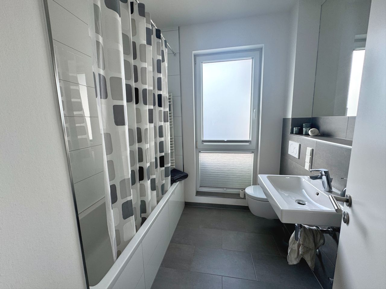 modernes Wannen-Duschbad mit Fenster