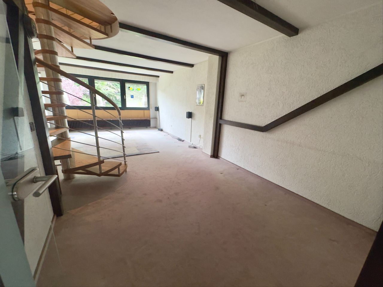 Wohnraum mit Wendeltreppe zum DG